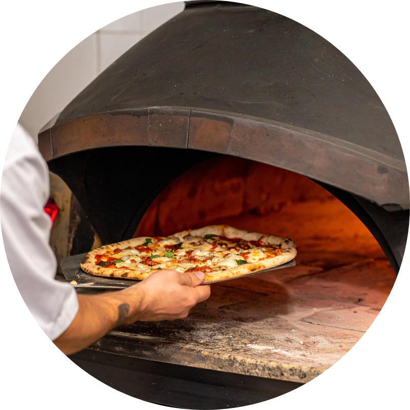 Cocinero cocinando una pizza casera en horno