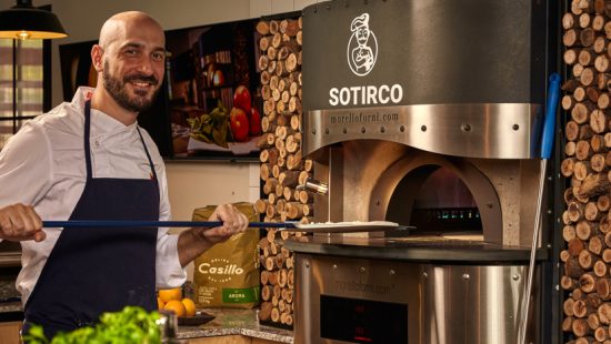 Profesional cocinando una pizza en horno